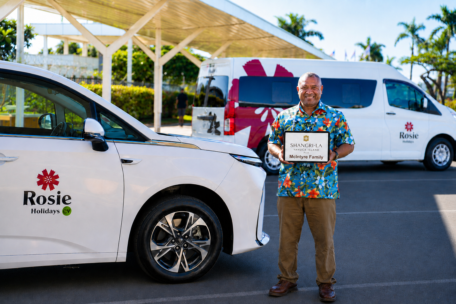 Rosie Holidays driver with Shangri-La Yanuca Island welcome sign beside EV fleet